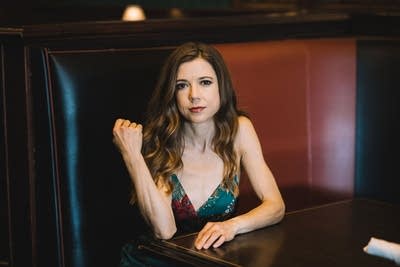 A woman sits at a table inside a restaurant