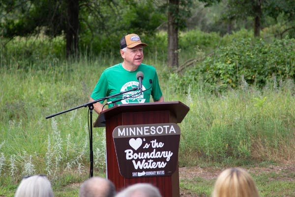 A man stands at a podium that reads "Minnesota Loves the Boundary Waters."