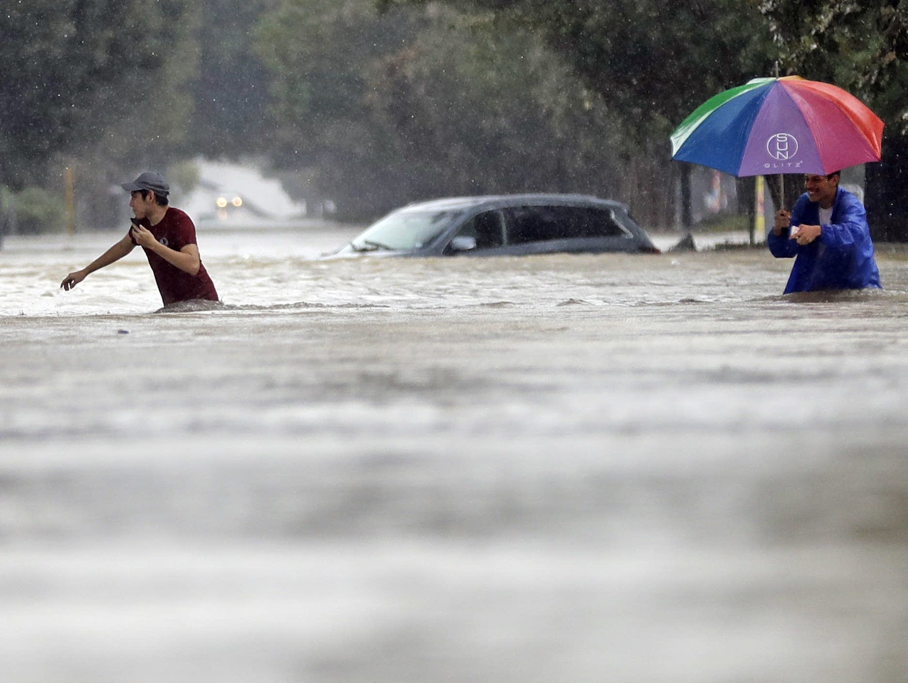 Moses Juarez Anselmo Padilla wade through floodwaters