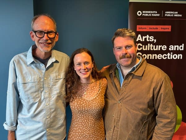 Three people stand together for a portrait