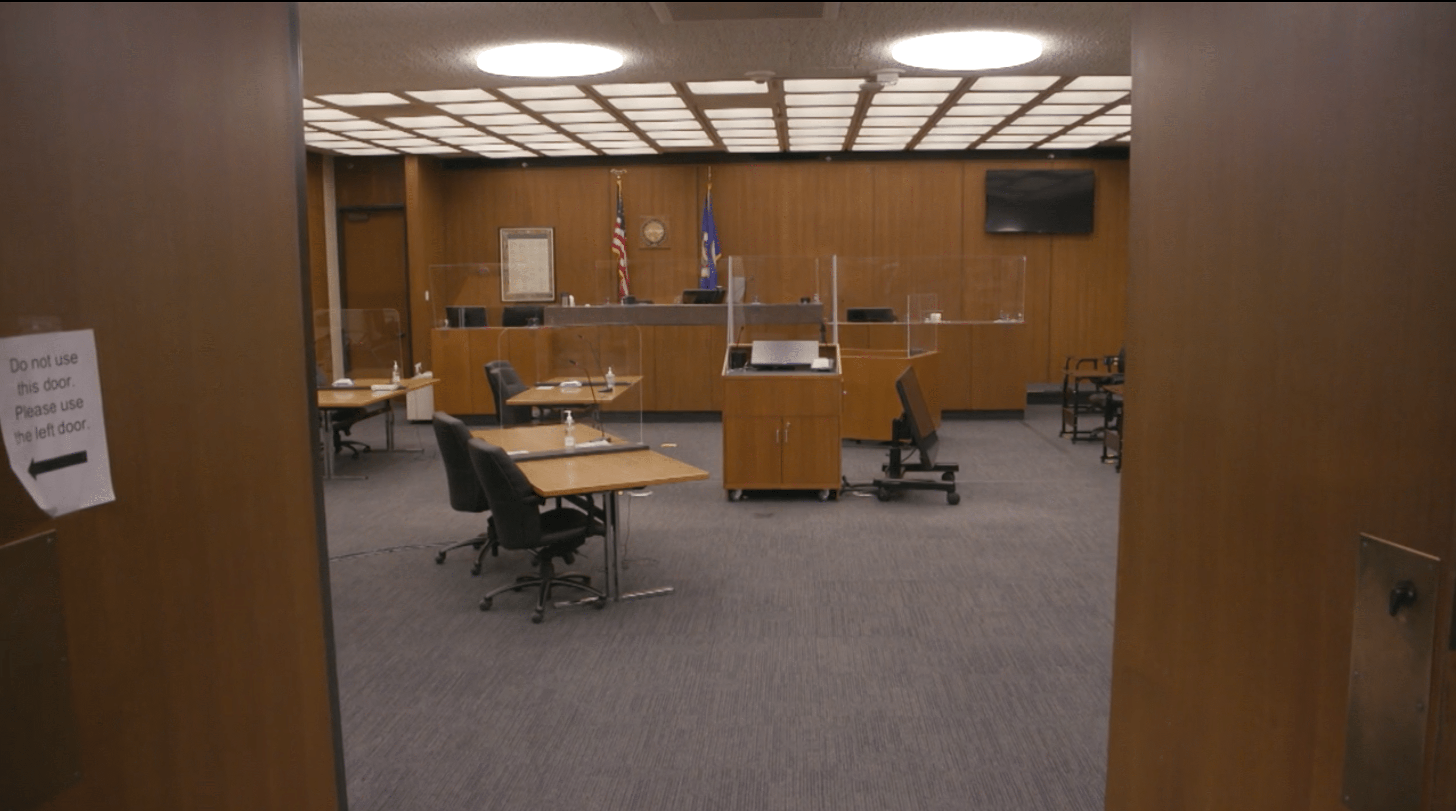 The inside of a courtroom with plastic barriers.