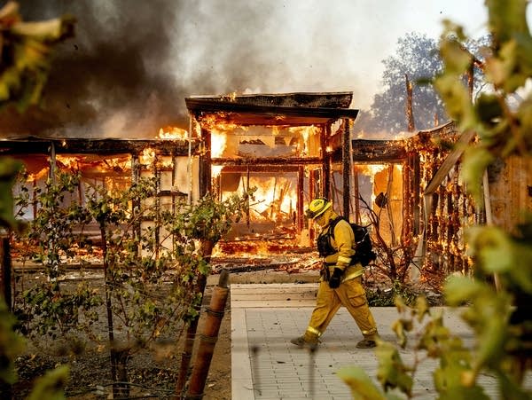 Woodbridge firefighter Joe Zurilgen passes a burning home