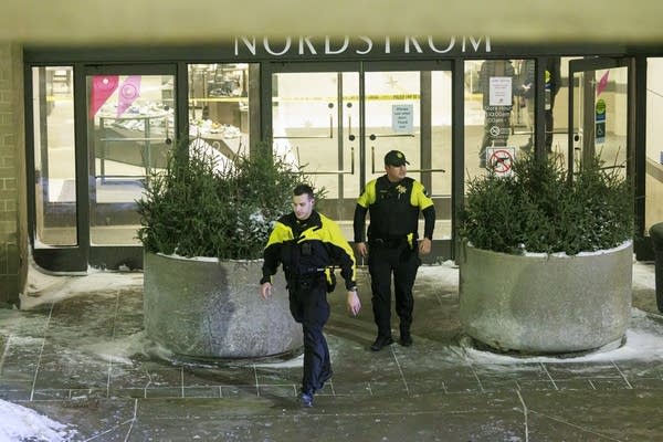 Two police officers walking out of a store