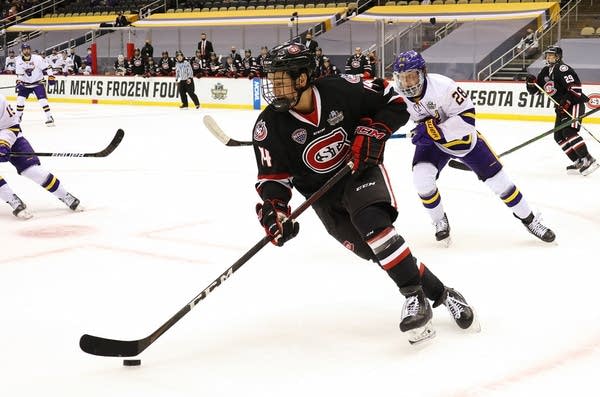 A hockey player moves the puck during a game. 