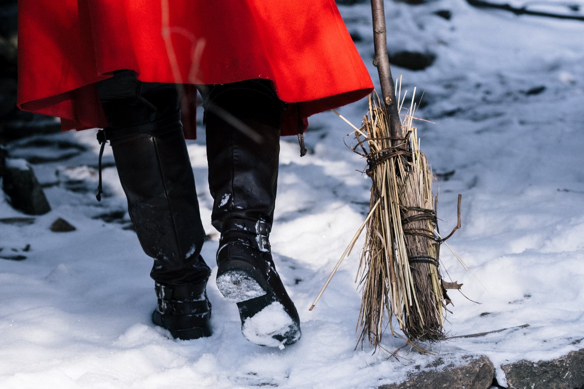 Katie Carrot sweeps snow off stick fort steps.