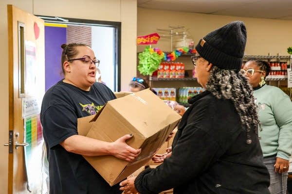 two people carrying a cardboard box