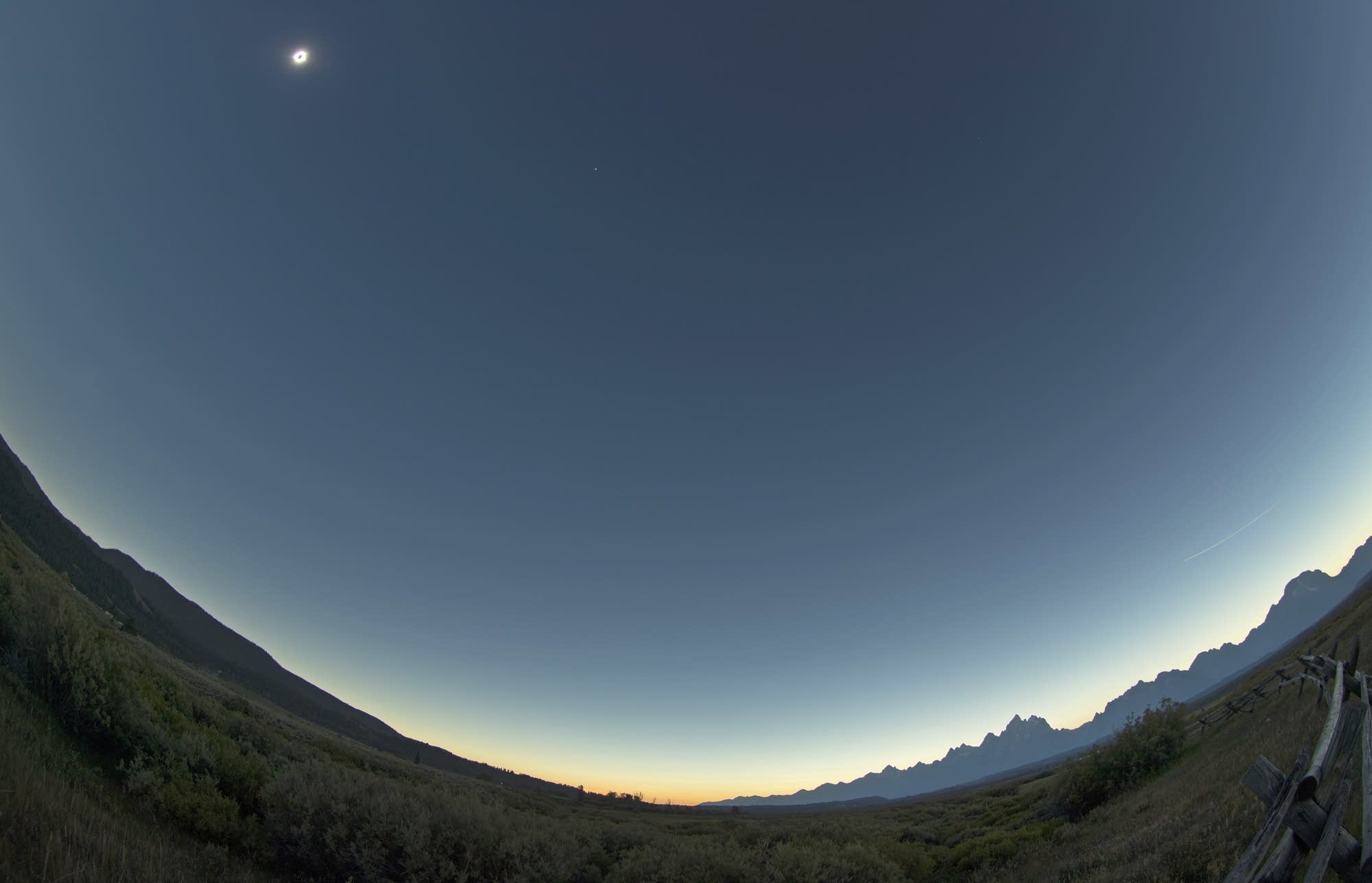 The sun is in full eclipse over Grand Teton National Park.