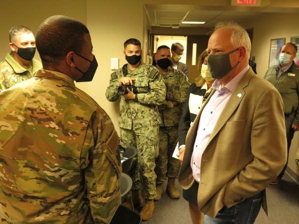 the governor speaks with men in military uniform inside a building