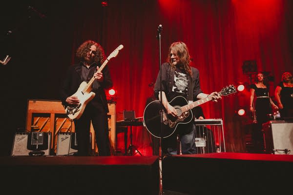 Two guitarists performing together onstage