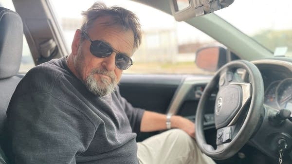 A man sits in a car.