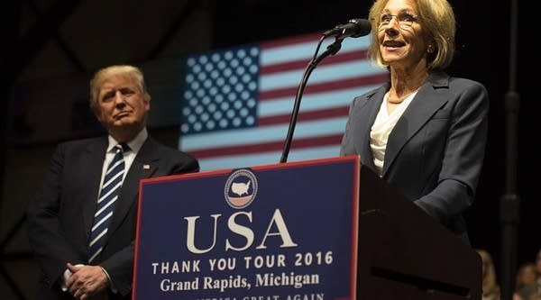 US President-elect Donald Trump listens as Betsy DeVos, his pick for education secretary, speaks during the USA Thank You Tour December 9, 2016 in Grand Rapids, Michigan. 
