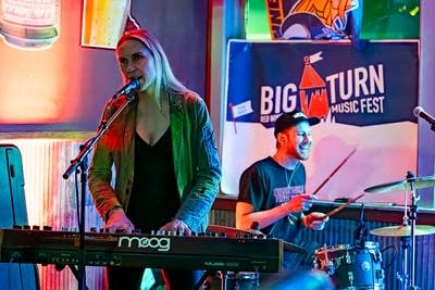 Two musicians perform together onstage