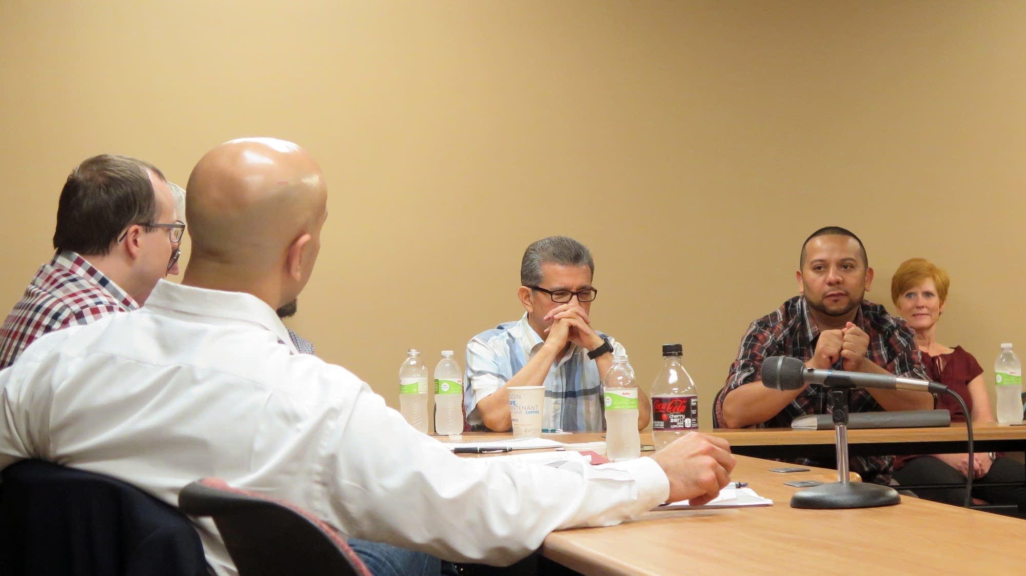 Neel Kashkari listens to an immigrant business owner in Worthington.