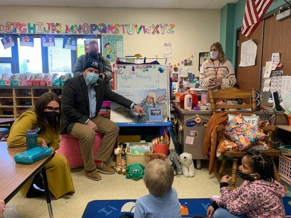 A man tours an elementary school classroom.