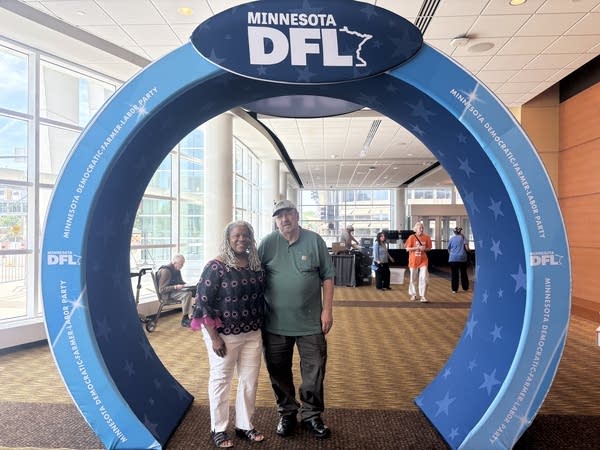 Two people pose for a photo at a DFL convention gate.