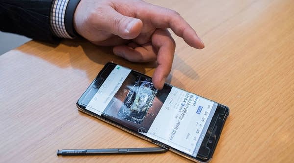A Samsung customer browses a web page showing a fire-damaged Samsung Note 7 mobile phone, on a similar device, at a Samsung store in a mall beneath the company's headquarters in the Gangnam district of Seoul on October 12, 2016. 