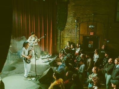 SoulFlower's Inayah El-Amin sings into a microphone at Fine Line.
