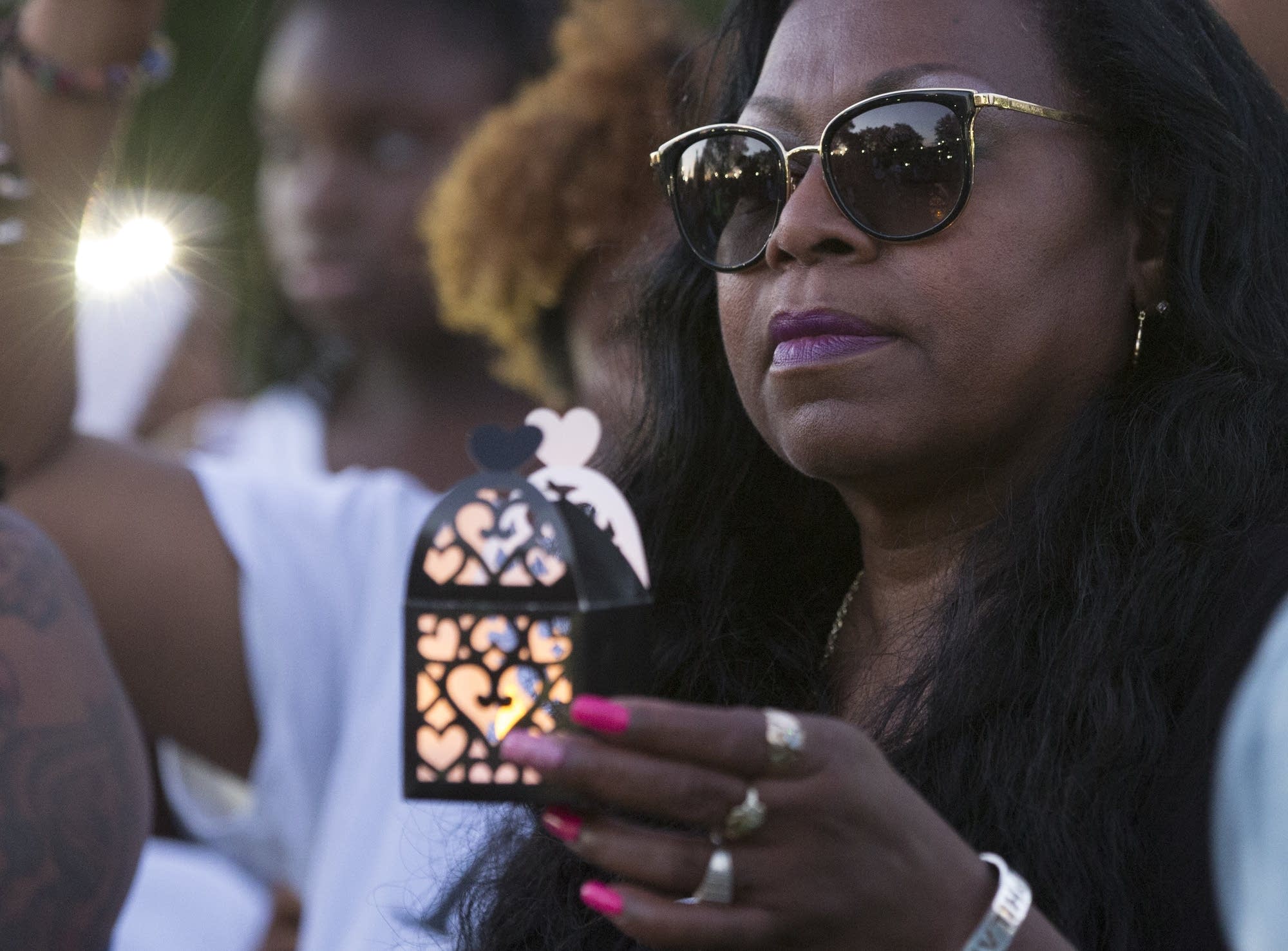 Valerie Castile holds a lantern during Pastor Danny Givens' speech.
