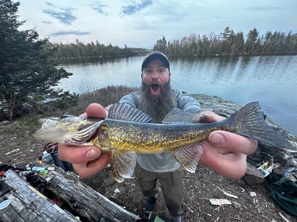 A man holds up a fish.