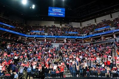 A crowd holds up Trump signs and do the wave.