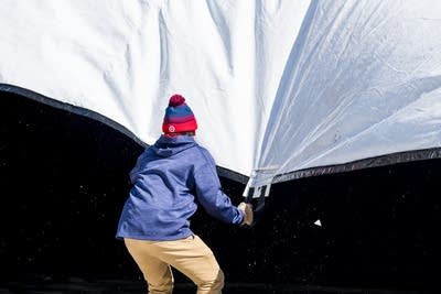A Target Field employee pulls down an inflated tarp