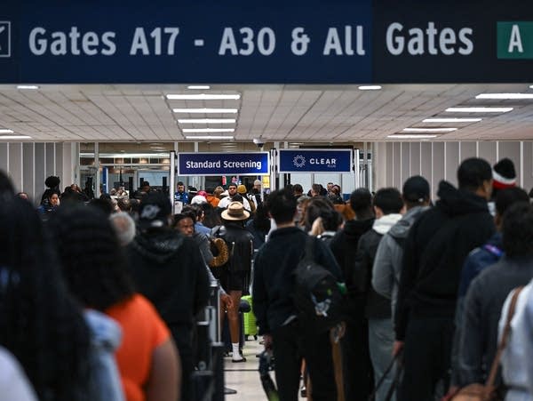 People wait in a long line at airport security.