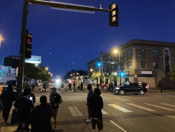 A small group stand in empty streets.