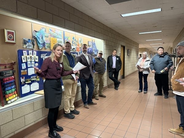 A woman shows people around a community center