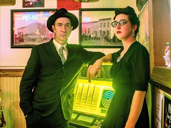 Two people standing beside a jukebox