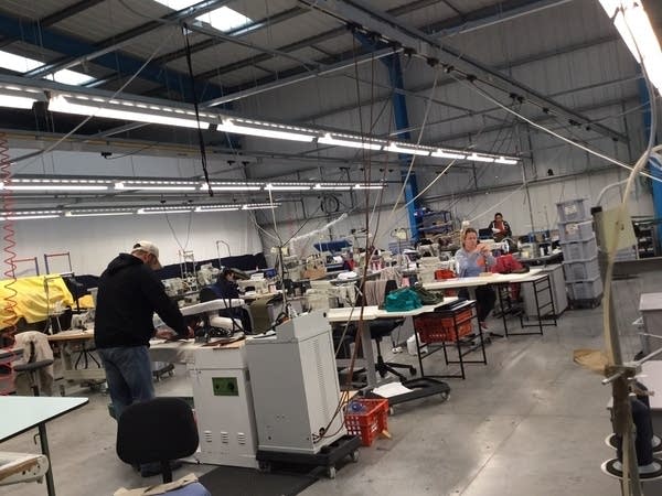 People work inside of a textiles factory.