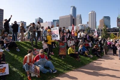 People sit down during a rally