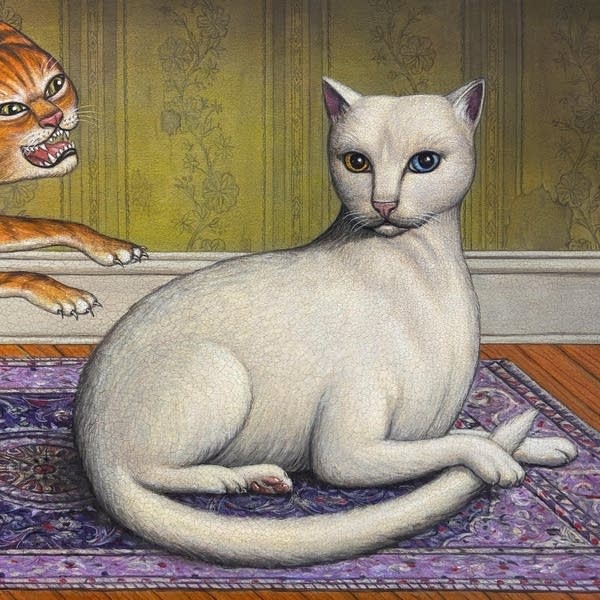 A cat rests placidly on a rug while another cat is about to pounce from behind