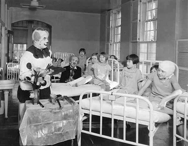 Circus clowns entertain children about 1930.