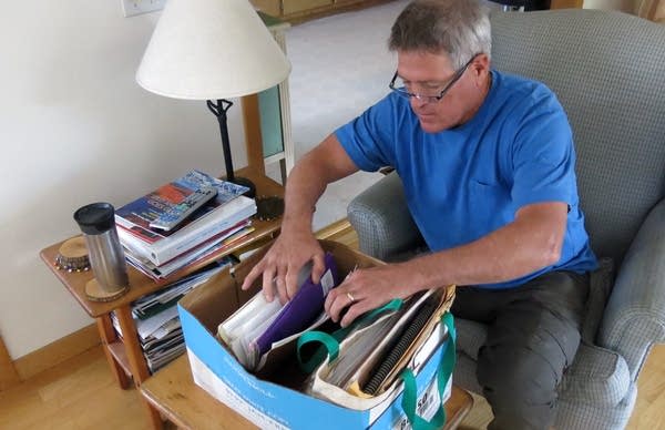 Mike Foy thumbs through a box of his old files. 