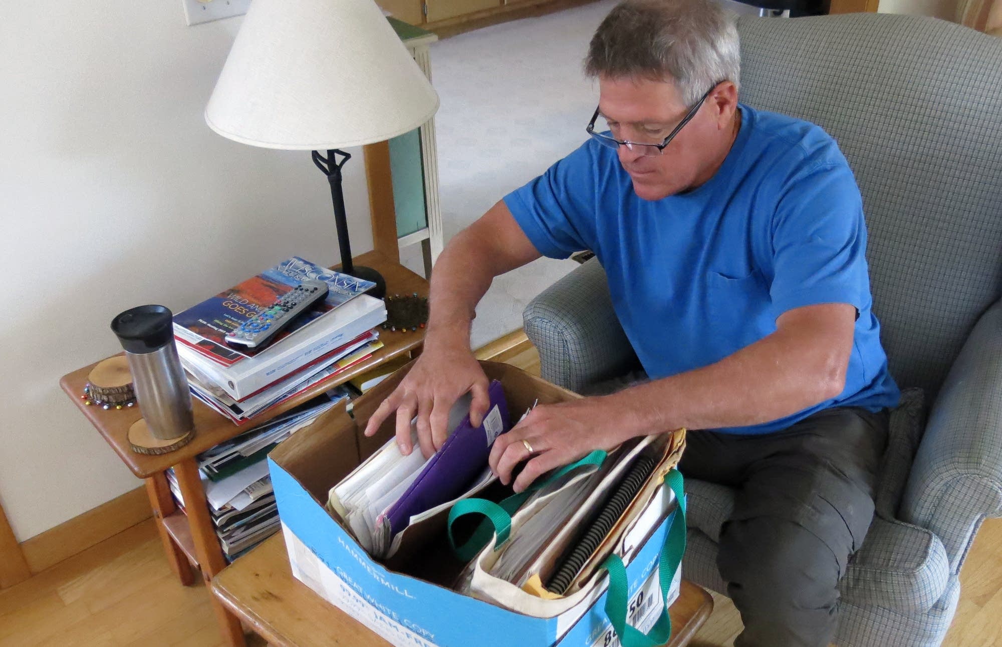 Mike Foy thumbs through a box of his old files.