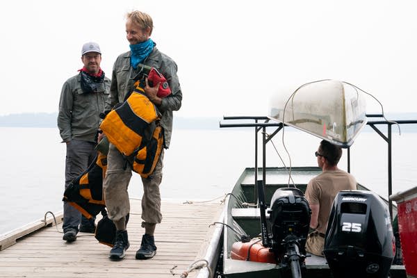 Two people carry their stuff
