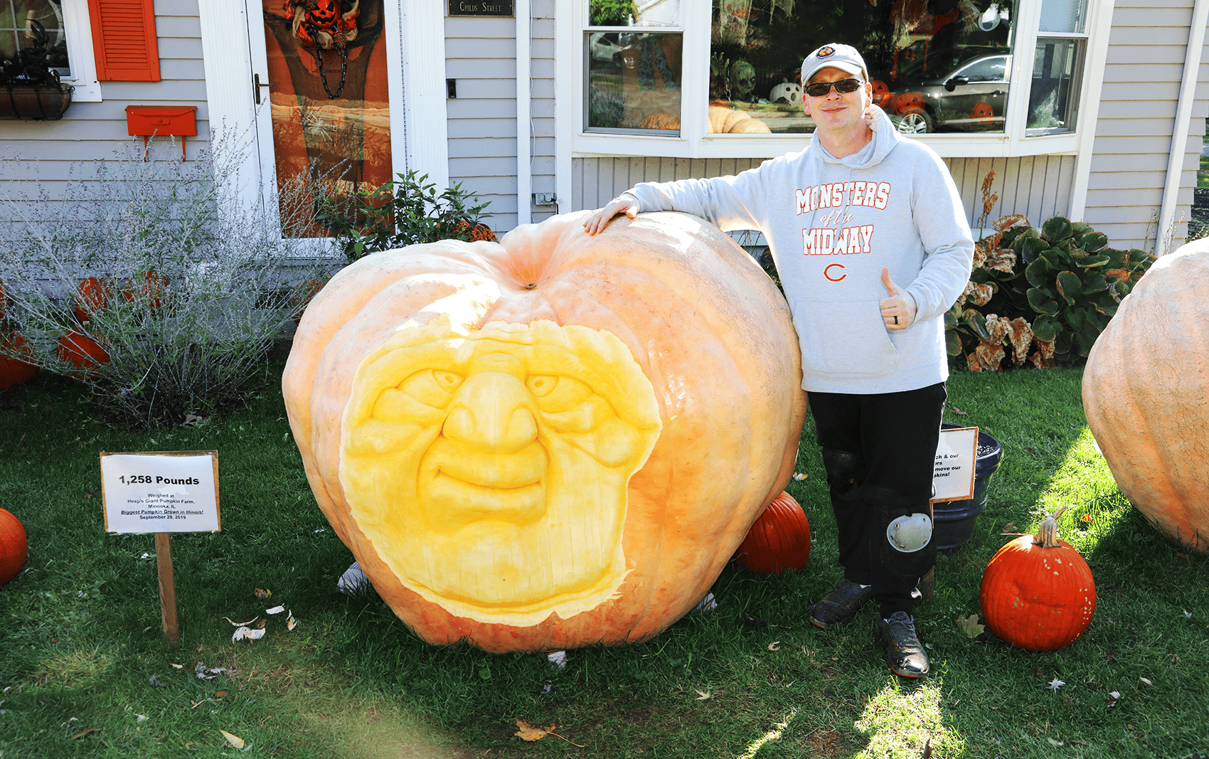 84e54f-20251021-a-person-poses-with-their-giant-carved-pumpkin-1700 These Midwesterners raise giant pumpkins