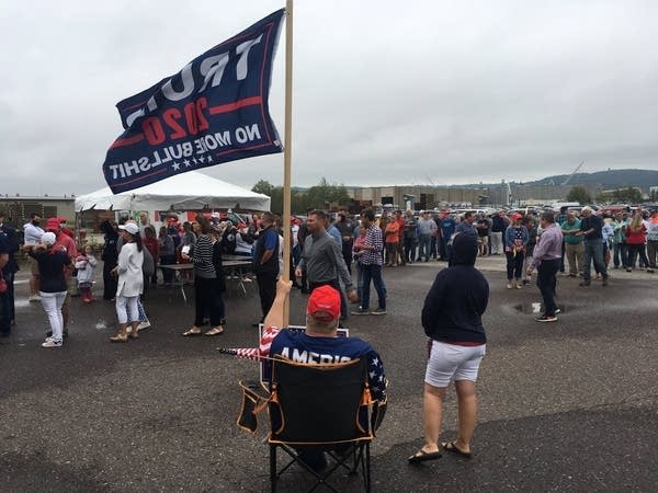 A Trump-Pence supporter sits in a chair 