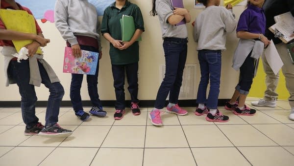Migrant teens line up for a class