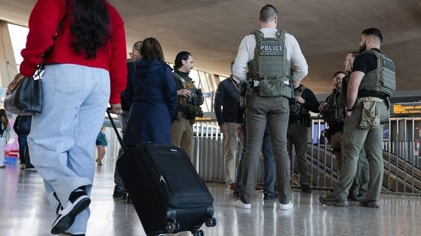 Above, ICE agents at Virginia's Dulles International Airport on Tuesday.