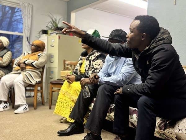 A man raises his hand while talking