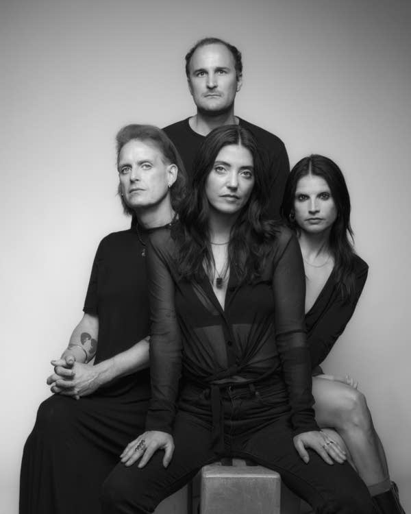 Four people gather for a studio portrait