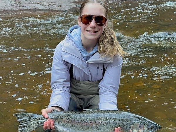 A woman in water holding a fish