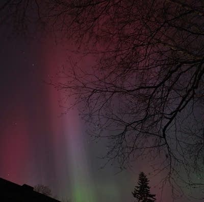 Green, red and purple lights in a night sky.