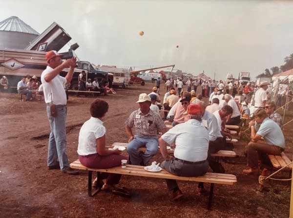 a group of people sit at benches.