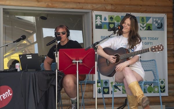 Two women on an outdoor stage at a fair