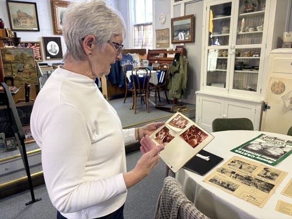 A woman holds and looks at a photograph.