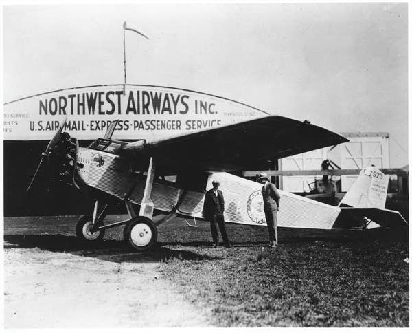 A black and white image of a plane at an airport.