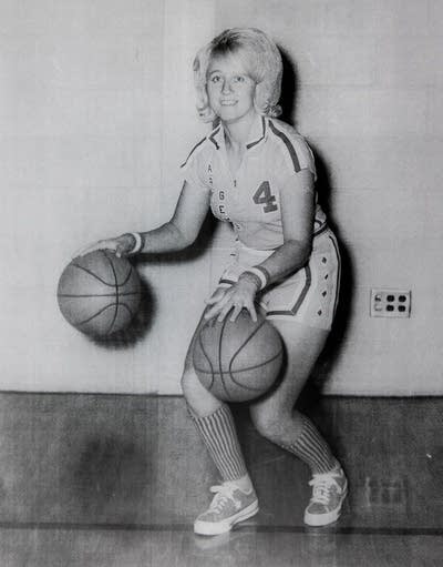 A woman poses with a basketball