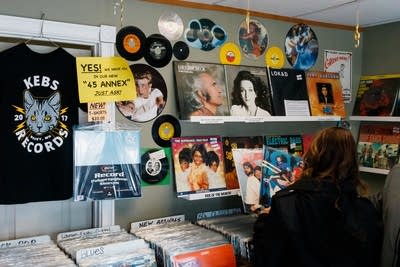 A person looks at an array of vinyl records in a record store